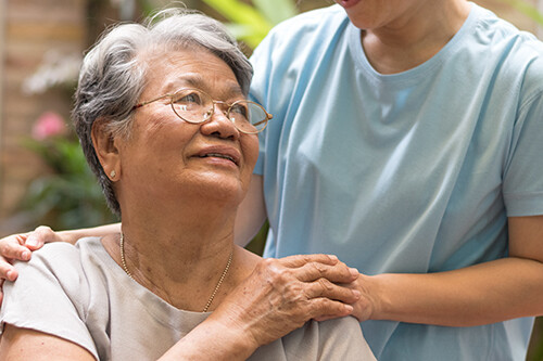 Caregiver, carer hand holding elder hand woman.